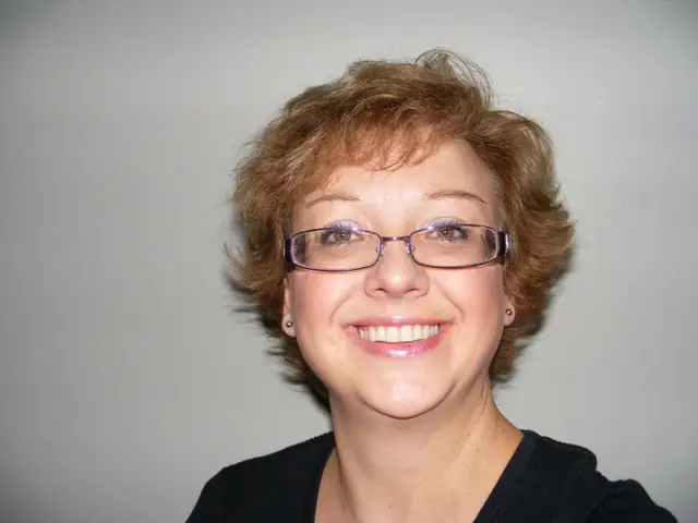 Chaplain Barbel Wray smiling, short auburn hair and glasses